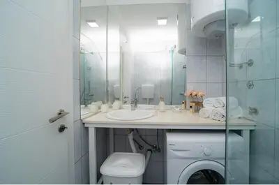 a bathroom with a toilet and a sink and a mirror at Apartment Pavle near the center with a view in Kotor
