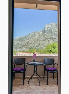 a balcony with a table and chairs and a mountain at Apartment Pavle near the center with a view in Kotor