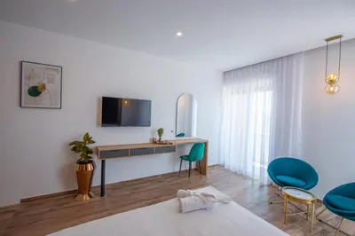 a room with a desk and chairs and a tv at Cataleya Resort in Ulcinj
