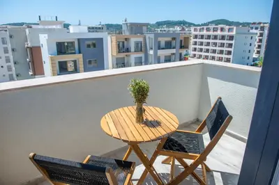 a wooden table with two chairs and a laptop on a balcony at Cataleya Resort in Ulcinj