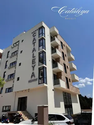a white building with a sign on it at Cataleya Resort in Ulcinj