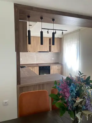 a kitchen with a counter and a table with flowers at Apartmani Radmanovic in Tivat