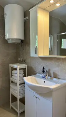 a bathroom with a white sink and a mirror at Apartmani Radmanovic in Tivat