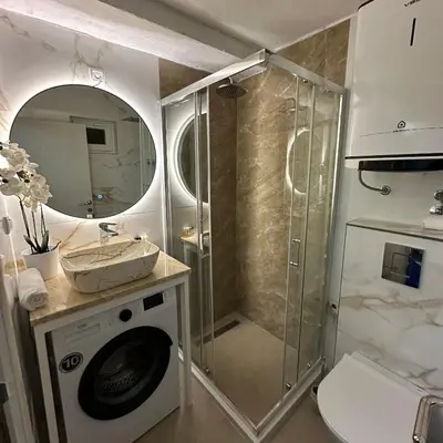 a bathroom with a shower and a washing machine at Apartman Budva Centar in Budva