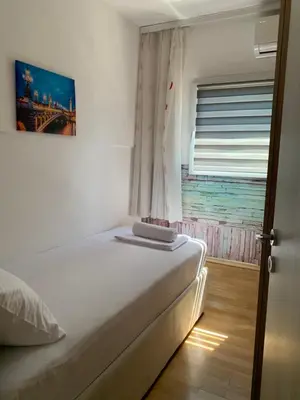a bedroom with a white bed with a window at Apartman Budva Centar in Budva