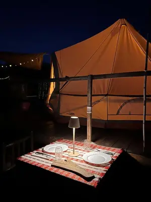 a table with two plates and an umbrella at Tranquil Tent Retreat Glamping in Zaljevo