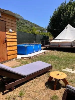 a bed and a table and a tent in a yard at Tranquil Tent Retreat Glamping in Zaljevo