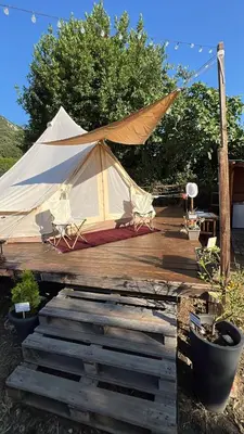 a tent on a wooden deck with two chairs at Tranquil Tent Retreat Glamping in Zaljevo