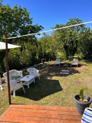 a group of chairs and an umbrella in a yard at Tranquil Tent Retreat Glamping in Zaljevo