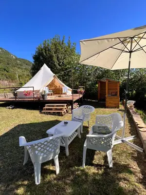 a table and chairs and an umbrella and a tent at Tranquil Tent Retreat Glamping in Zaljevo