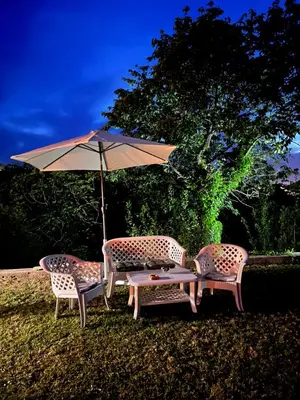 three chairs and a table with an umbrella at Tranquil Tent Retreat Glamping in Zaljevo