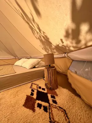 a bedroom with a tent with a rug in front at Tranquil Tent Retreat Glamping in Zaljevo
