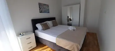 a small bedroom with a bed and a night stand at Al Mare in Ulcinj