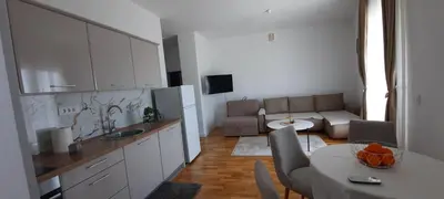 a kitchen and living room with a table and a couch at Al Mare in Ulcinj