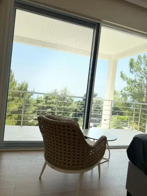 a chair and a table in a room with a large window at Montesea Villa in Gornji Sušanj