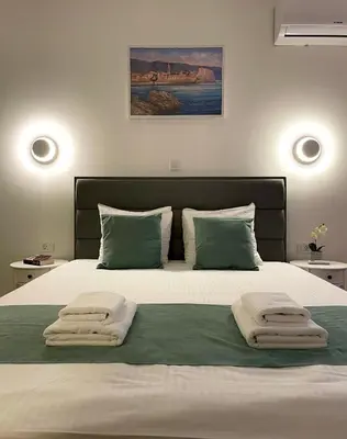 a bedroom with a large bed with towels on it at Bofani Apartments Budva in Budva