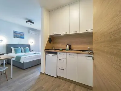 a kitchen and a bedroom with a bed and a table at Bofani Apartments Budva in Budva