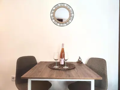 a table with two wine glasses and a mirror at Bofani Apartments Budva in Budva