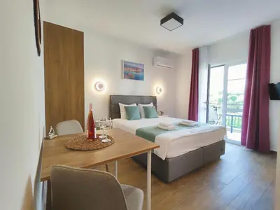a bedroom with a bed and a table with chairs at Bofani Apartments Budva in Budva