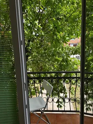 a white chair sitting on a balcony with a window at Studio Nik in Cetinje