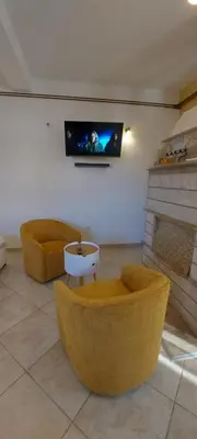 a living room with two chairs and a tv on the wall at Vaso & Viktor Apartment in Kotor