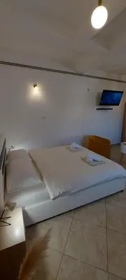 a white bed in a room with a wall at Vaso & Viktor Apartment in Kotor