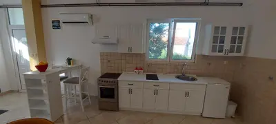 a kitchen with white cabinets and a sink and a stove at Vaso & Viktor Apartment in Kotor