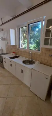 a kitchen with a sink and two windows at Vaso & Viktor Apartment in Kotor