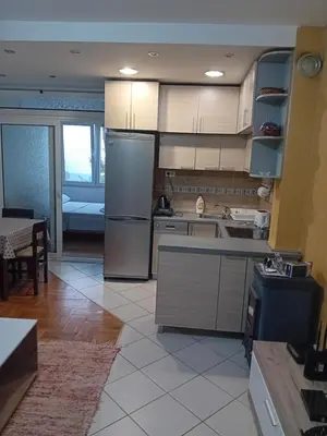 a kitchen with a stainless steel refrigerator and a table at Apartman,,Siv,, Prijevor in Budva