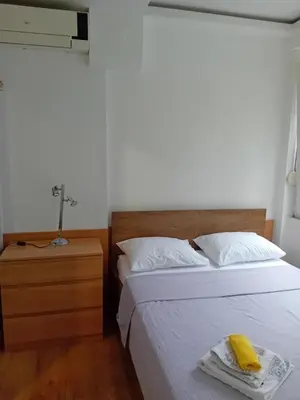 a bedroom with two beds and a nightstand with a yellow towel at Apartman,,Siv,, Prijevor in Budva