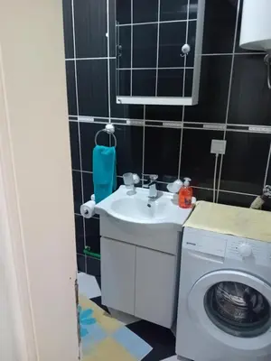 a bathroom with a sink and a washing machine at Apartman,,Siv,, Prijevor in Budva