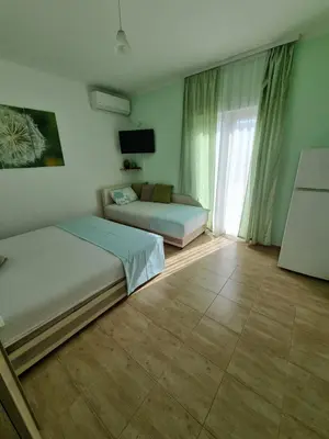 a bedroom with two beds and a couch and a window at DMD Apartments in Budva