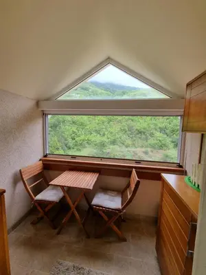 a table and two chairs in a room with a large window at DMD Apartments in Budva