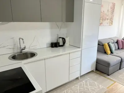 a white kitchen with a sink and a couch at Era Apartments in Ulcinj