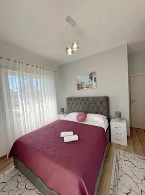 a bedroom with a large bed with two towels on it at Era Apartments in Ulcinj