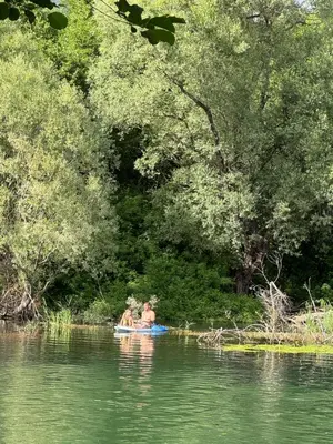 two people in a paddle boat on a river at NikolaS Family cottage in Cetinje