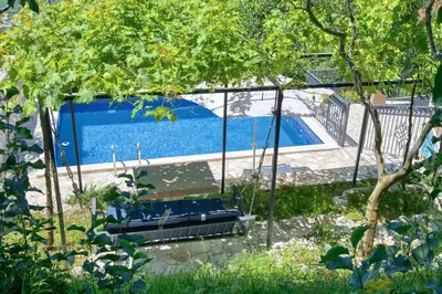 a group of chairs sitting next to a swimming pool at Apartment Paradise in Kotor