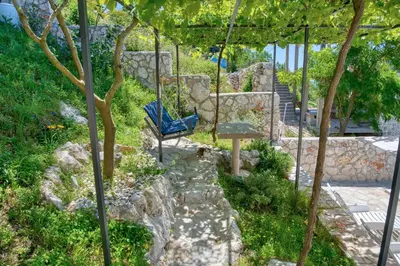 a blue bench sitting in the middle of a garden at Apartment Paradise in Kotor