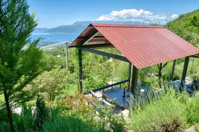 a building with a red roof with a view of the ocean at Apartment Paradise in Kotor