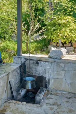 a metal bell is hanging over a stone fireplace at Apartment Paradise in Kotor