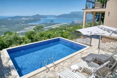 a swimming pool with chairs and a view of the water at Apartment Paradise in Kotor
