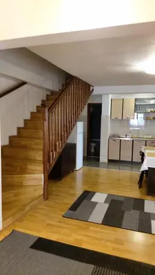 a living room with a staircase and a kitchen at Engie Apartment in Budva