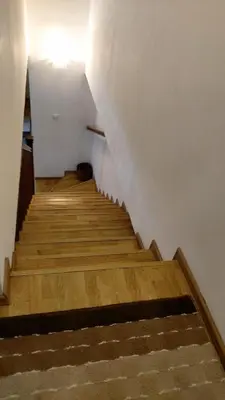 a staircase with wooden floors and a white wall at Engie Apartment in Budva