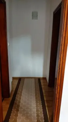 an empty room with a white wall and a wooden floor at Engie Apartment in Budva