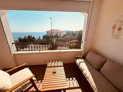a living room with a couch and a large window at Serenity Seaview Suite Przno in Pržno
