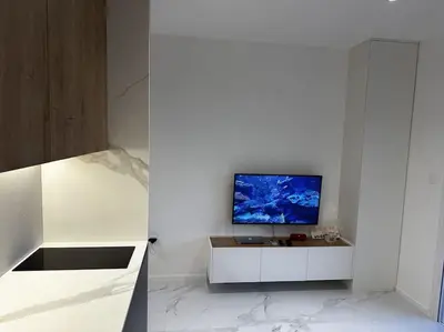 a kitchen with a tv on a white wall at Serenity Seaview Suite Przno in Pržno
