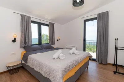 a bedroom with a large bed with a large window at Country home Dolac POOL&SAUNA in Bar
