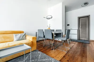 a living room with a couch and a table and chairs at Budva Gate by In Property in Budva