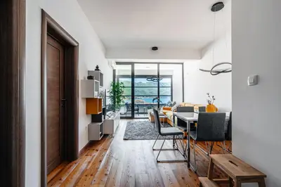 a dining room and living room with a table and chairs at Budva Gate by In Property in Budva