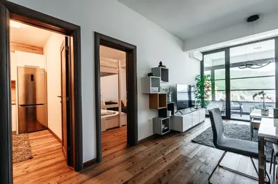 a living room with a table and a dining room at Budva Gate by In Property in Budva